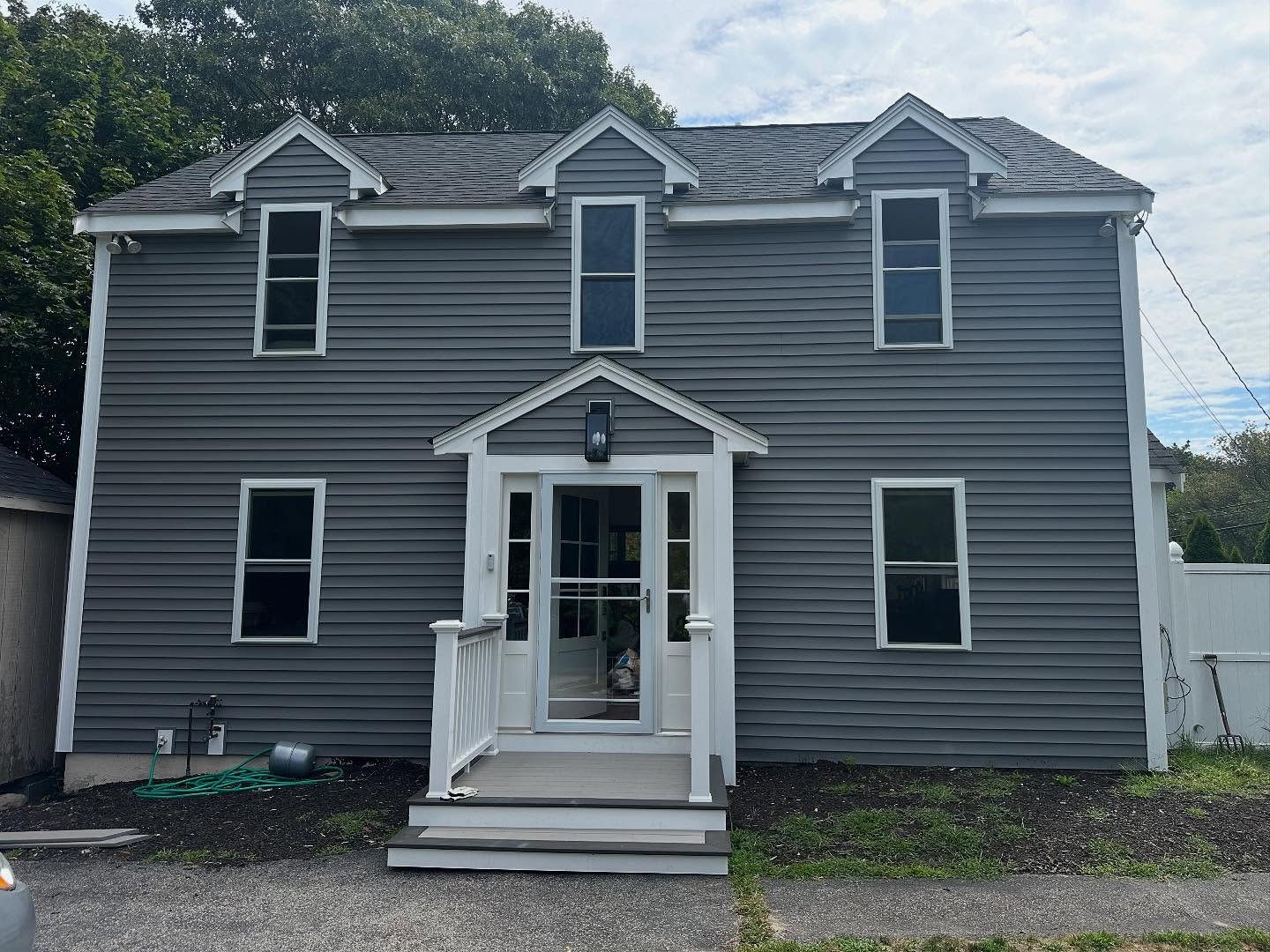 Completed Nessara Construction siding project&mdash;grey clapboard colonial with new white trim